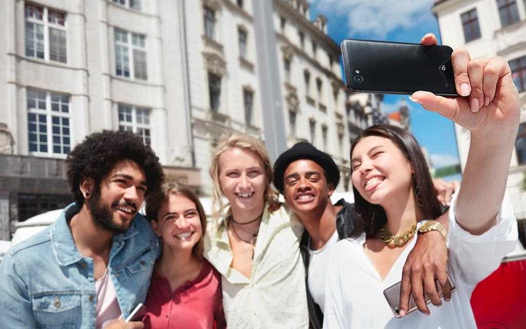 Group of friends taking selfie with new lg q6 with its wide angle selfie feature.