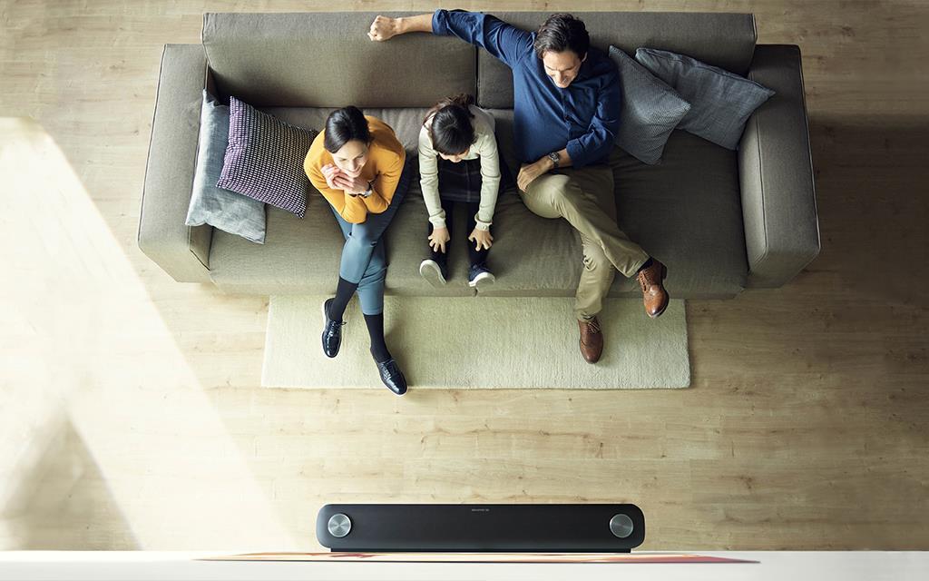 An image of a family enjoy watching movie in the living room with LG SIGNATURE W7 TV, which is Dolby Vision and Dolby Atmos compatible.
