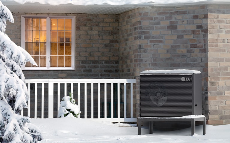 snowy landscape, showcasing a Therma V R290 Monobloc heat pump and a tree nearby