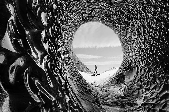 a black-and-white image of a person standing in the middle of a desert