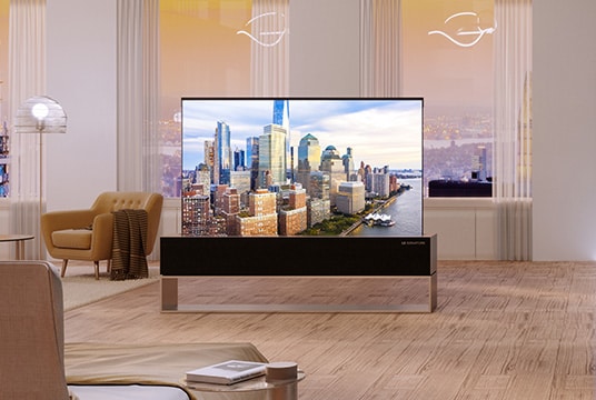 A wide view of the kitchen and the living room with LG SIGNATURE Rollable OLED TV in full view.