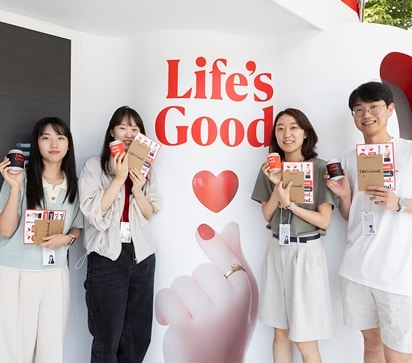 Employees are taking pictures with souvenirs in front of the Life's good truck.