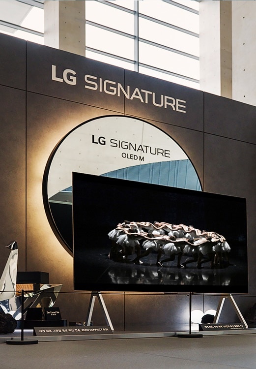 A ballet dancer is dancing in front of an LG Signature TV.