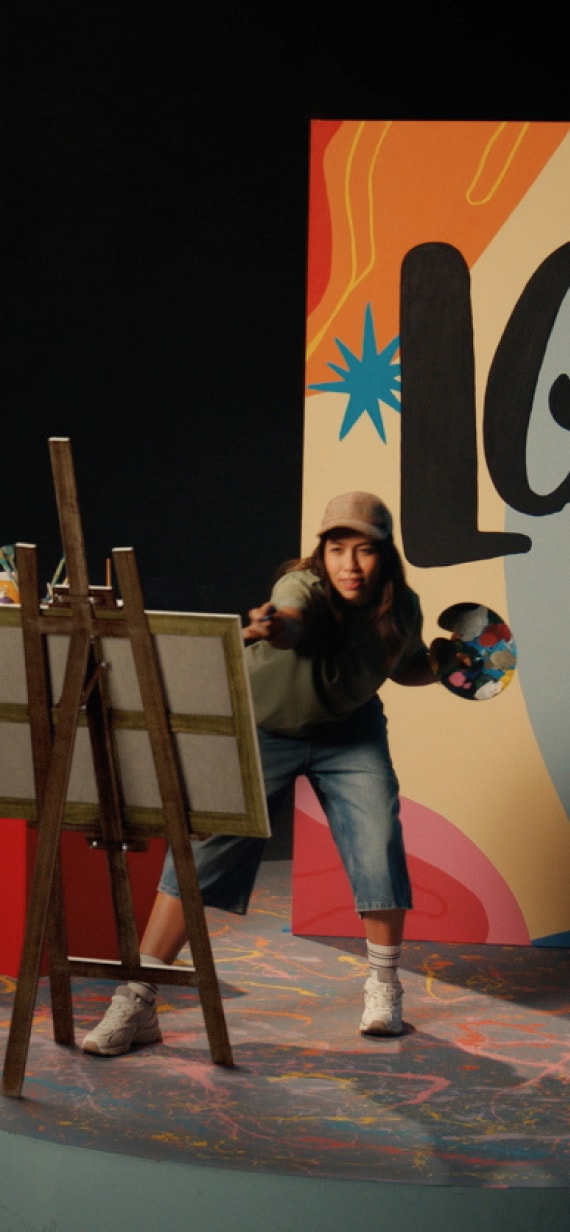 A female painter dynamically painting on a canvas.