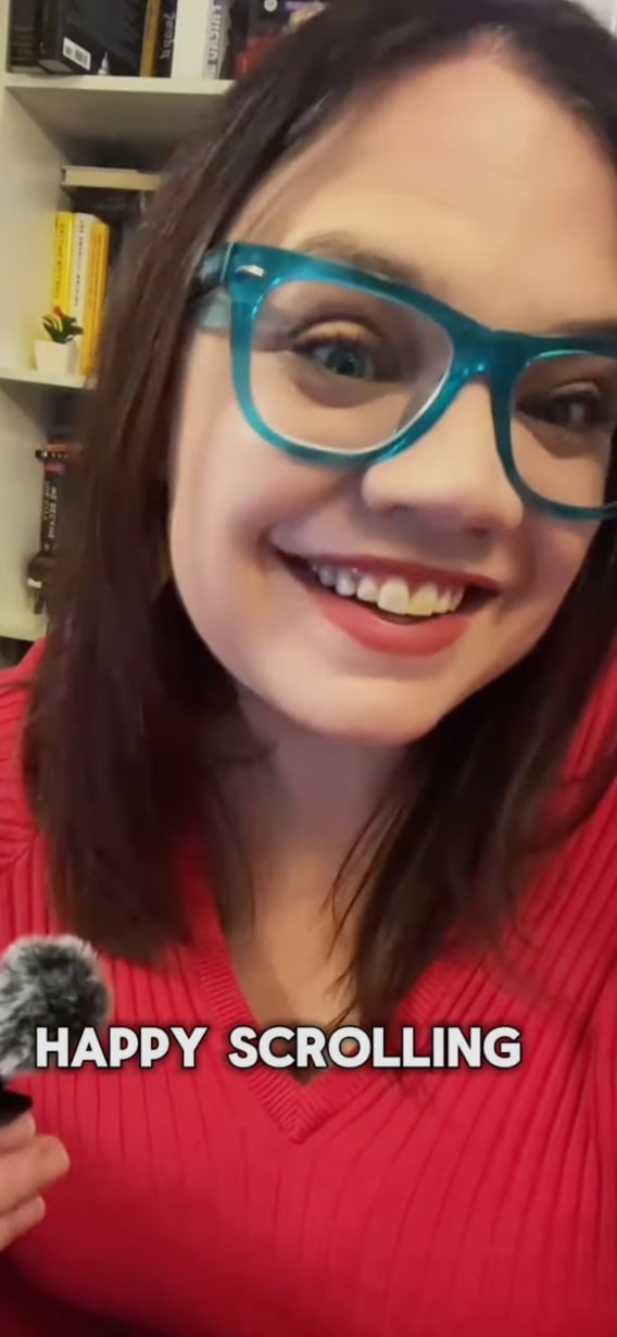 Mujer con gafas azules y un suéter rojo, sonriendo con el texto "HAPPY SCROLLING" en la parte inferior.