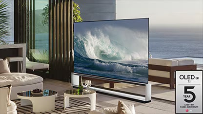 LG OLED Z2 in een minimalistisch ingerichte kamer voor een raam dat uitkijkt naar een bos