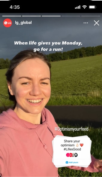 Smiling woman in a pink hoodie running on a sunny day.