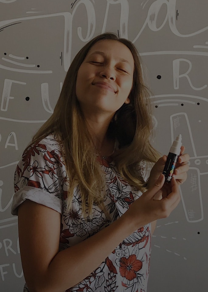 Karol Stefanni smiling, holding a white pen.