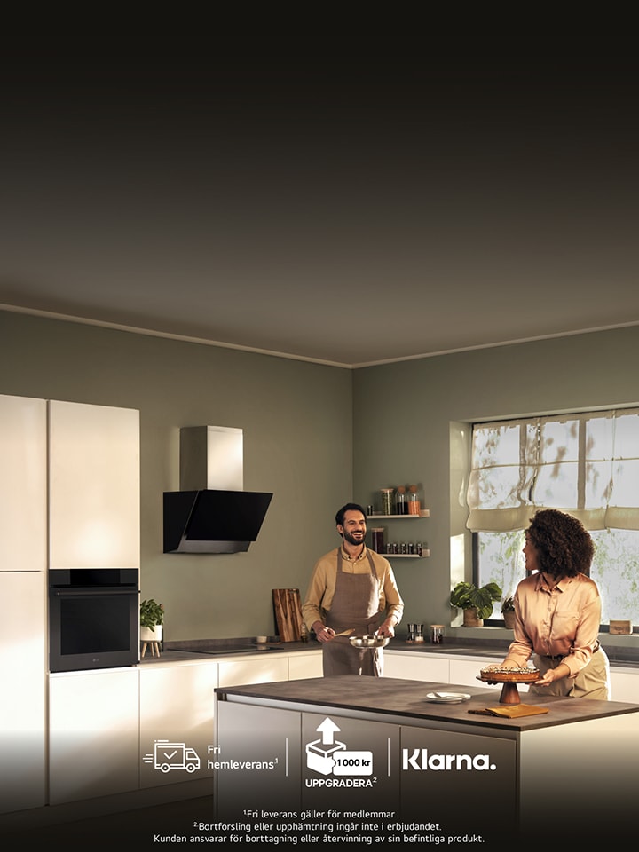 Modernt kök med man och kvinnor som ler och samtalar vid en köksö. Köket har stilrena vitvaror, mjuk belysning och ett stort fönster som släpper in naturligt ljus. Logotyper för varumärkena LG syns till vänster.