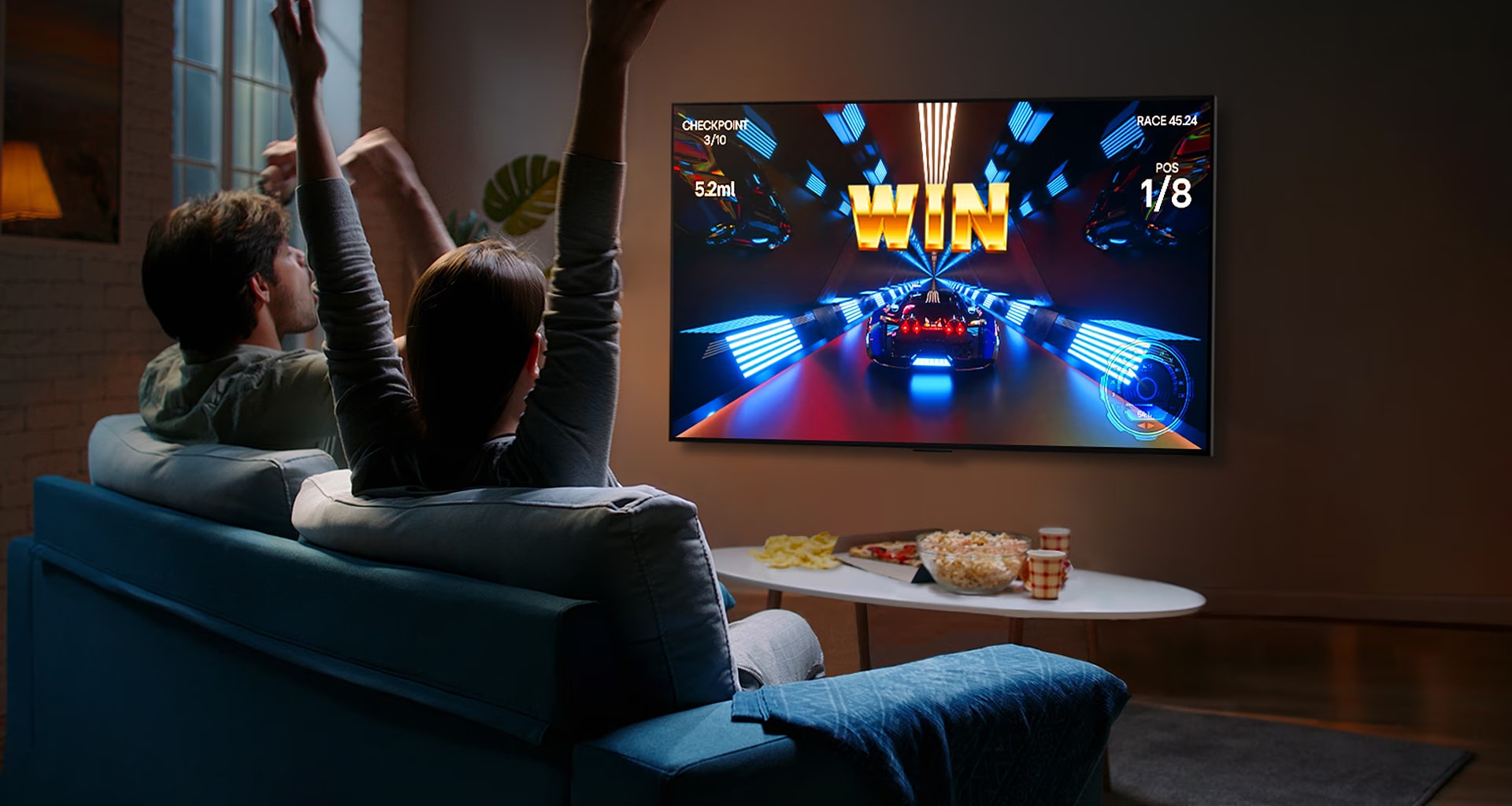 LG OLED televizyonun önünde kontrol cihazı ile oyun oynayan insanlar