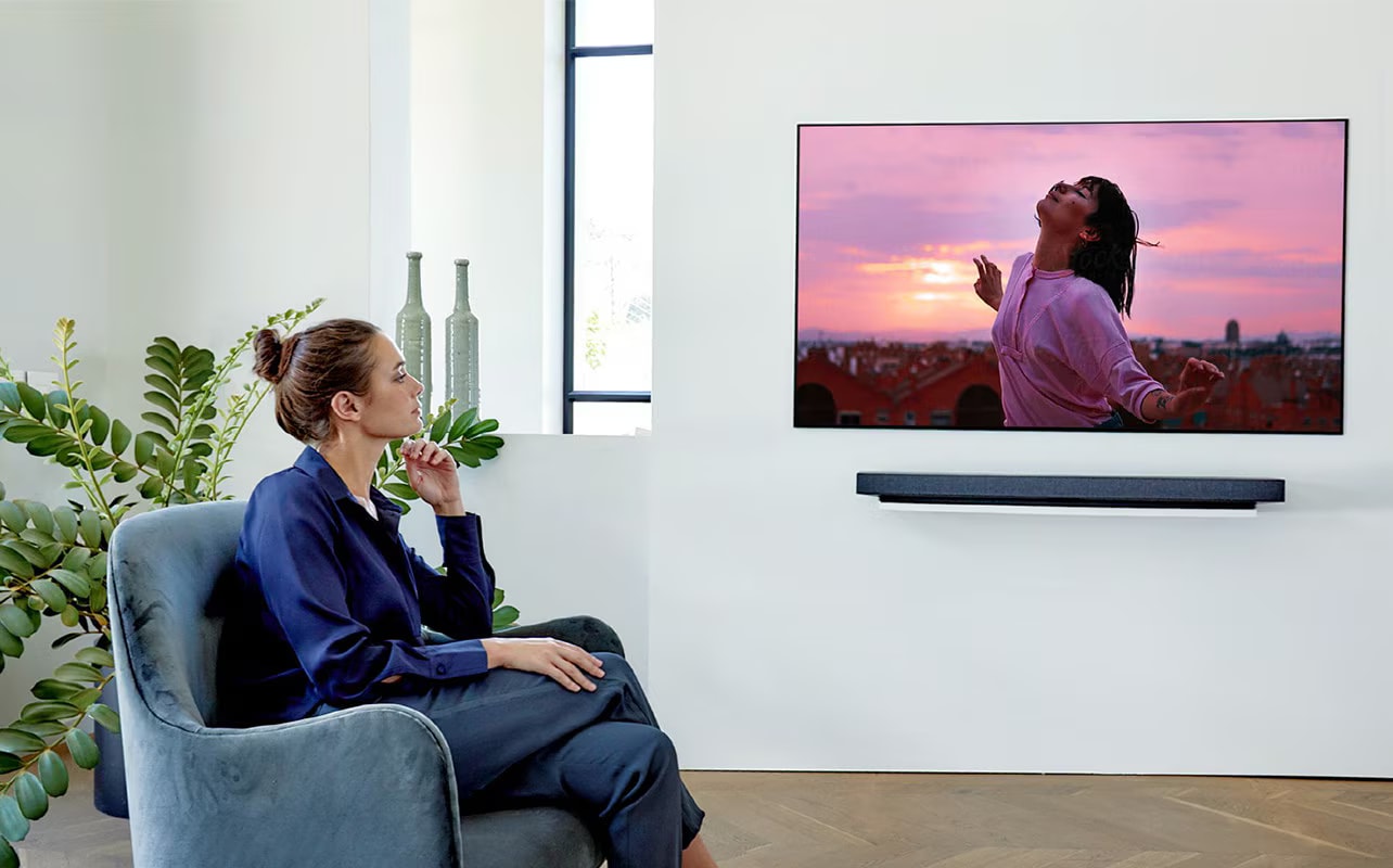 một người phụ nữ đang xem TV trên chiếc ghế dài