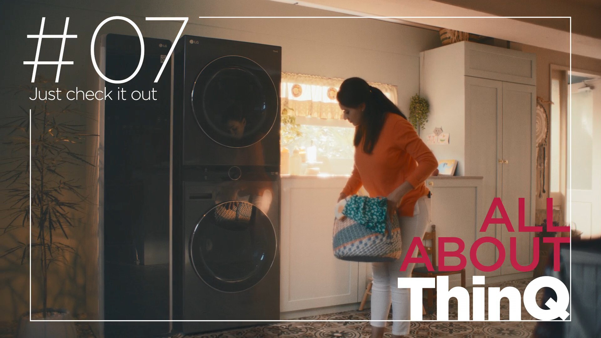 A woman standing in front of LG ThinQ washer.