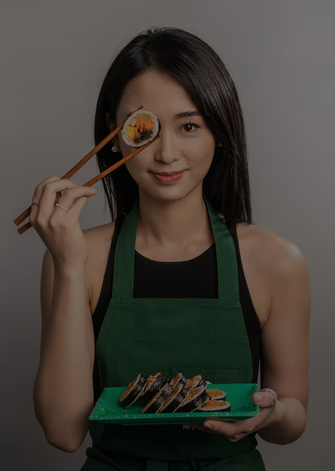 Tina Choi tinh nghịch cầm miếng kimbap gần mắt.