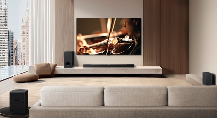 LG Soundbar, LG TV, ein Subwoofer und hintere Lautsprecher stehen in einer modernen Stadtwohnung. Der Hintergrund wird gedimmt und ein Raster wird über das Bild des LG TVs gelegt, wie ein Scan des Raums. Eine gepunktete Linie geht von einem der hinteren Lautsprecher aus, um die lineare Anordnung der beiden hinteren Lautsprecher zu zeigen. Aus der Frontalperspektive der hinteren Lautsprecher kommen aus Tröpfchen bestehende weiße Schallwellen.