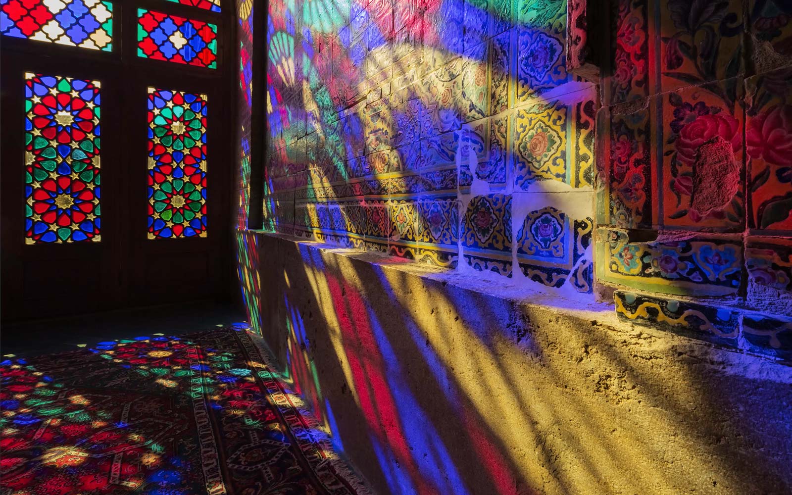 Una scena che mostra la luce che filtra attraverso le finestre di vetro colorato e proietta i colori su una parete (riproduci video).