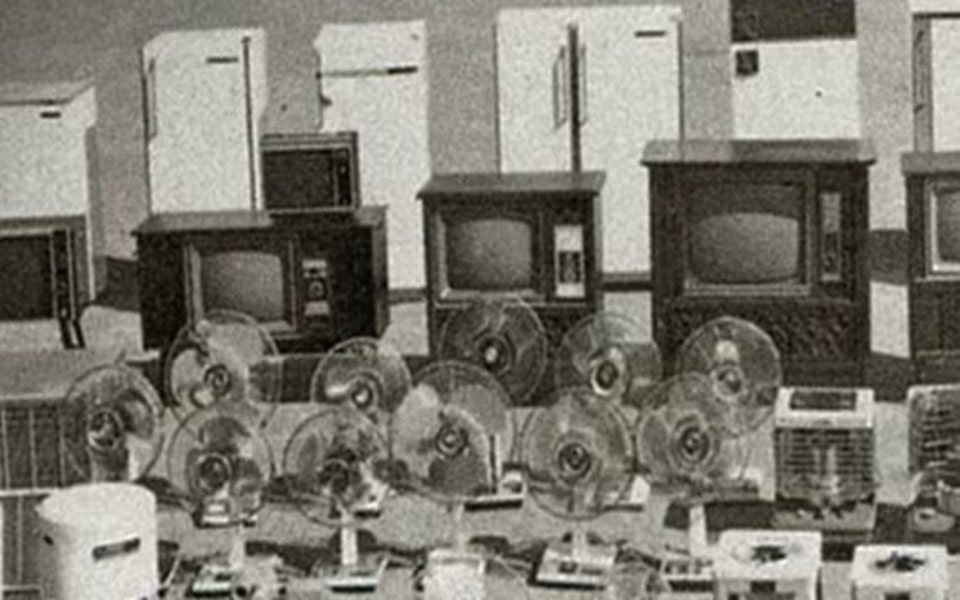 Reihen von Elektronikgeräten, darunter Kühlschränke, Fernseher, Ventilatoren und mehr, sind in Schwarz-Weiß ausgestellt.