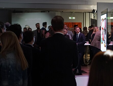Viele Menschen starren auf das OLED TV von lg signature auf der Kunstwoche in Deutschland
