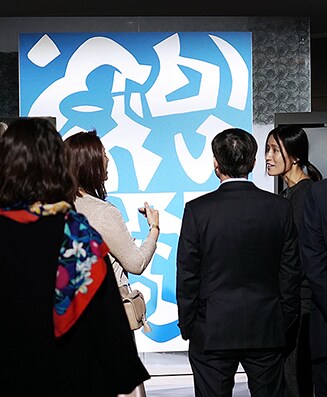 Mehrere Personen stehen vor dem künstlerischen Bild des Weinkellers von lg signature auf der Kunstwoche in Deutschland