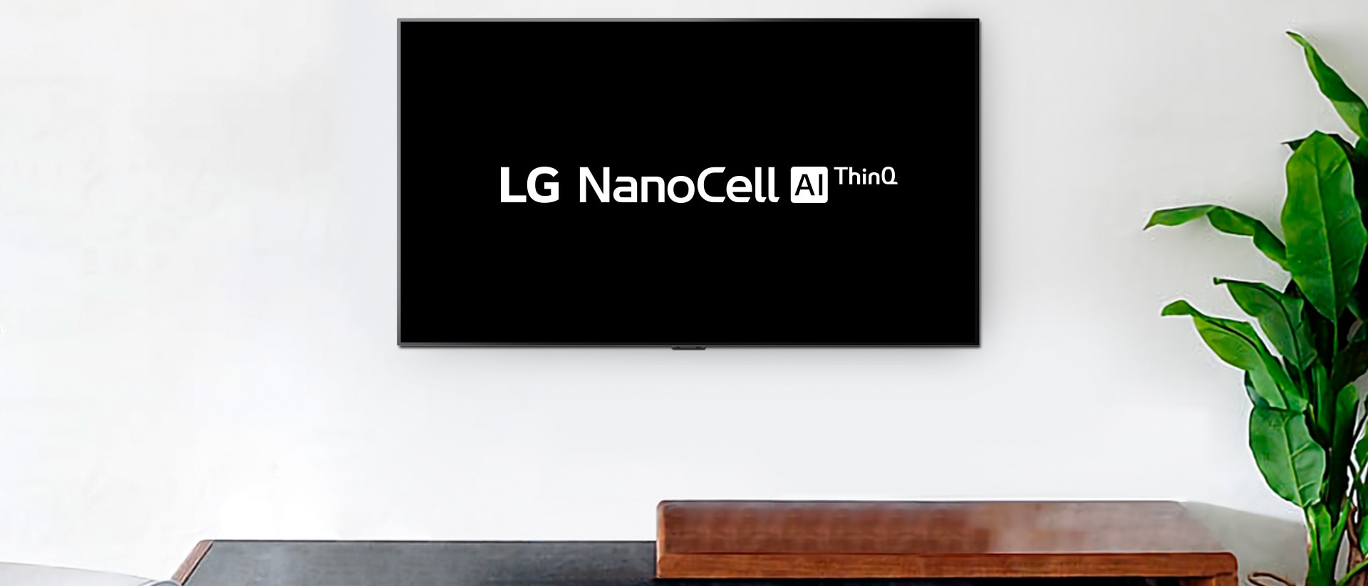 Vægmonteret tv, der viser LG OLED AI ThinQ-logo på sort baggrund