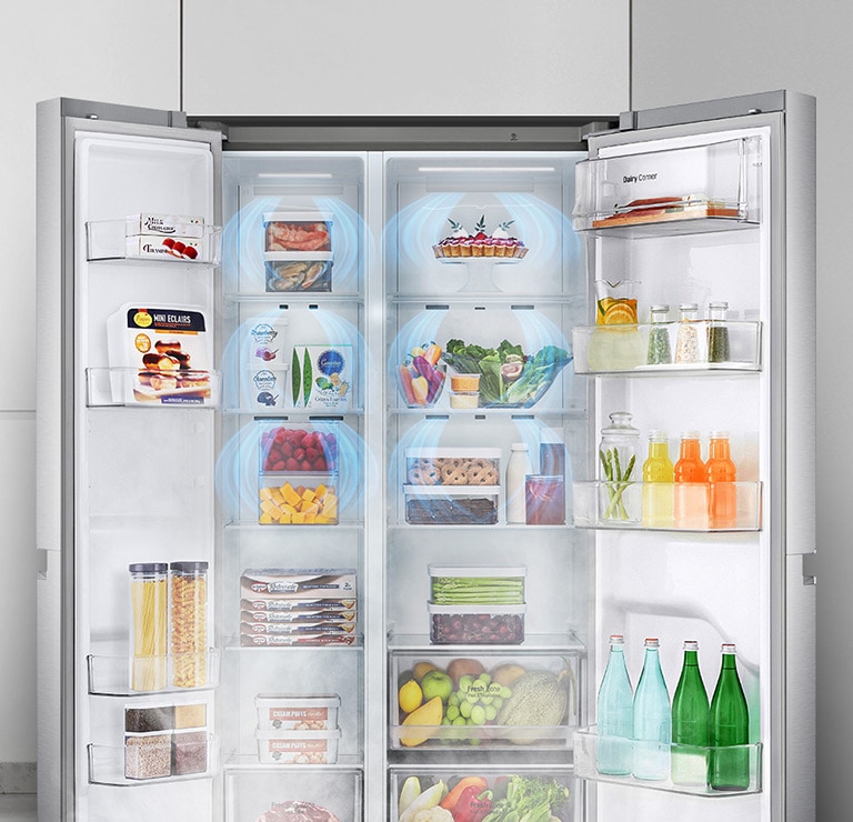 A front view of the refrigerator with the two front doors wide open showing a full stocked fridge. Blue clouds of mist are shown going down over all of the produce.