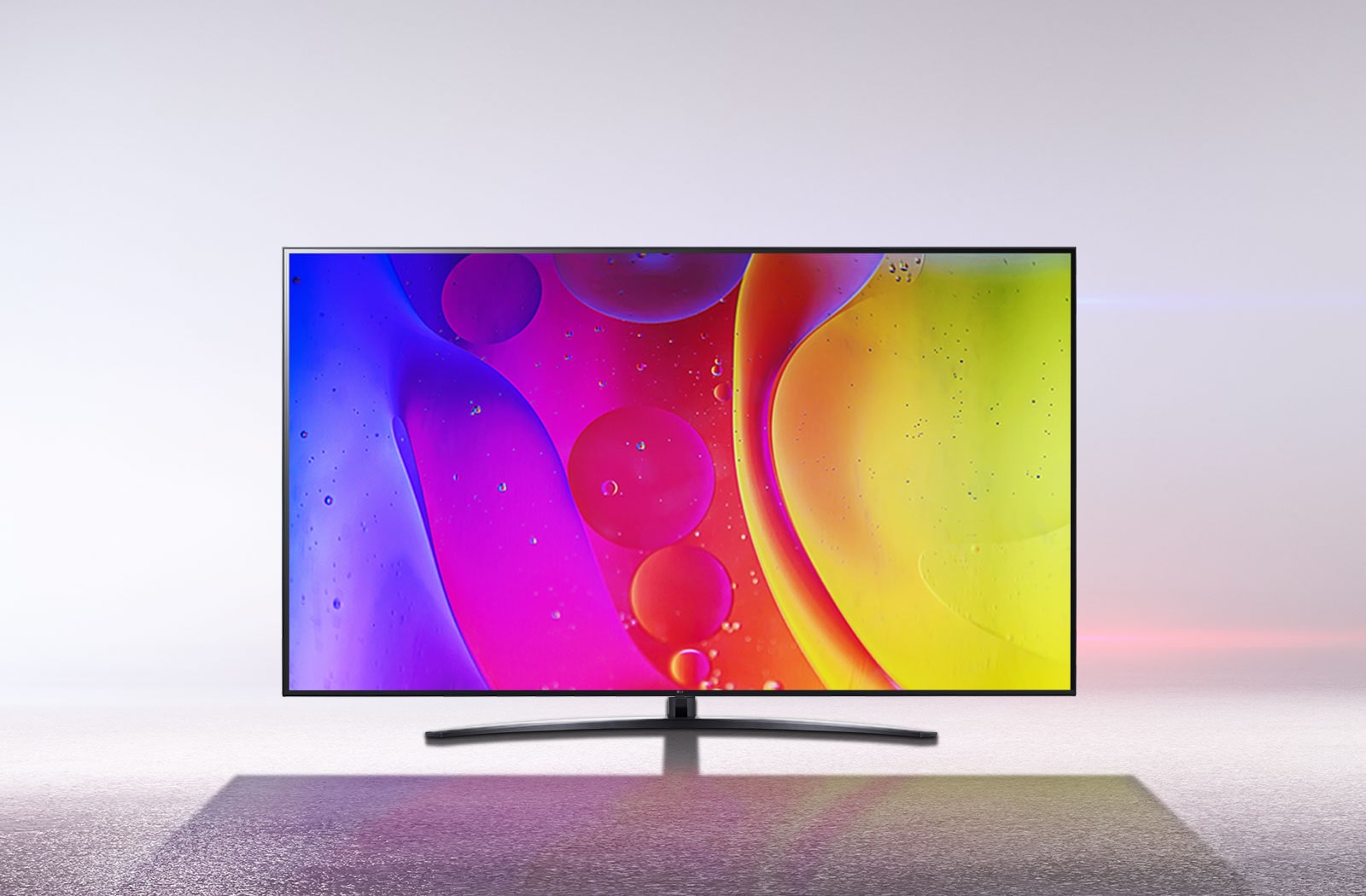تلفزيون في غرفة بيضاء صارخة يعرض ألوانًا ساطعة ومتحركة تنويمية على الشاشة.