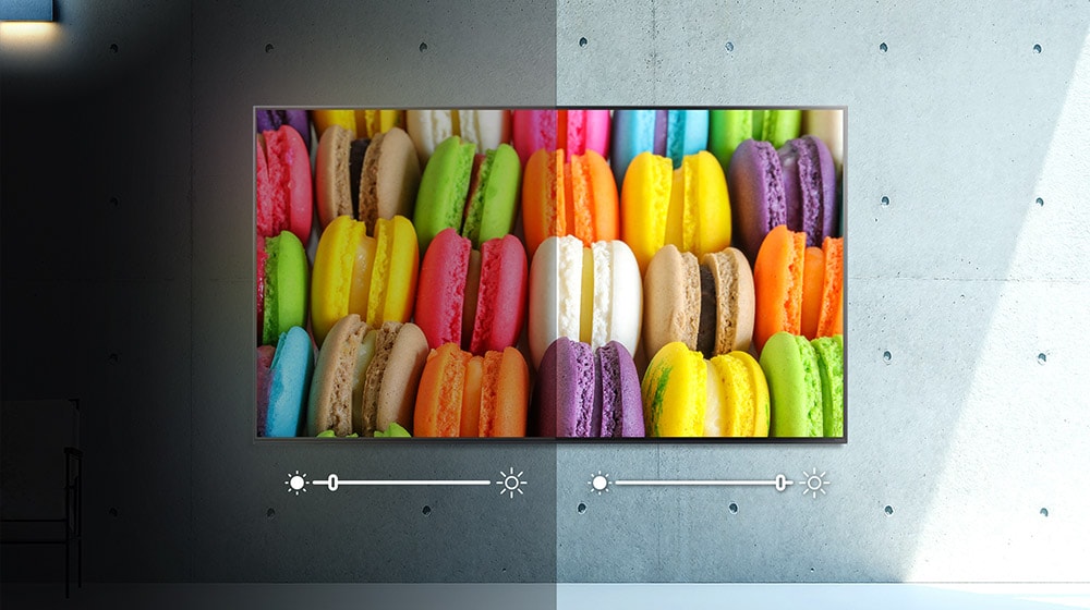 A screen, half in darkness, half in light, displays an image of a colorful macaron.  Brightness is adjusted on each side.