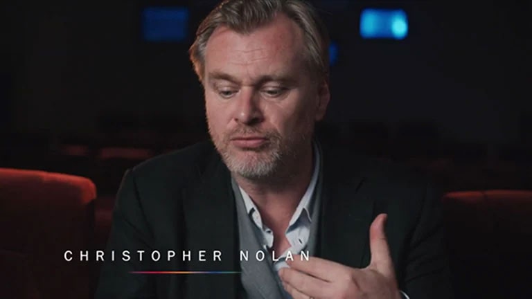 Christopher Nolan giving an interview in a theater room