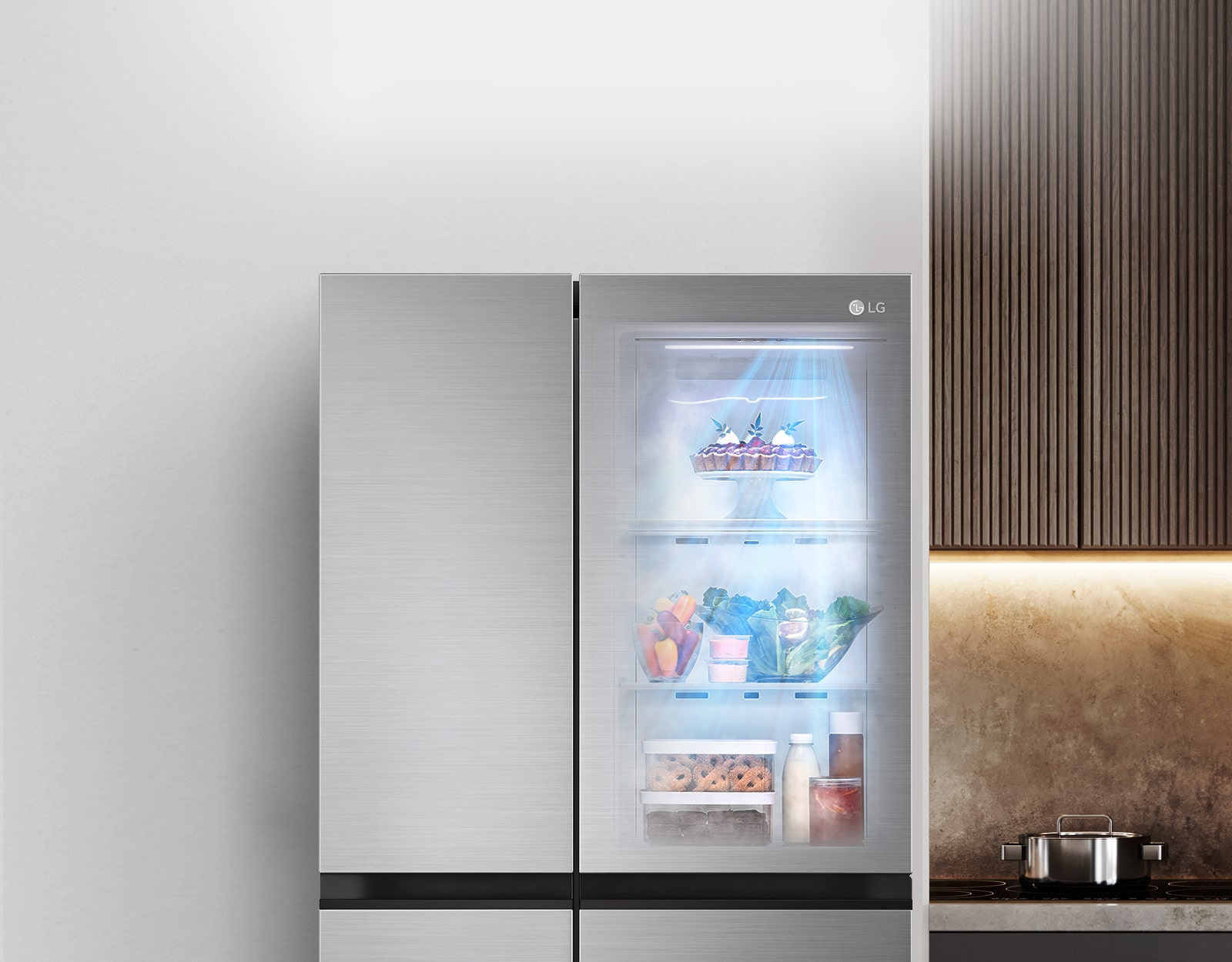 The front view of the InstaView refrigerator is black with lighting inside.  The contents of the fridge can be seen through the InstaView door.  Blue rays of light shine on the contents from the DoorCooling function.