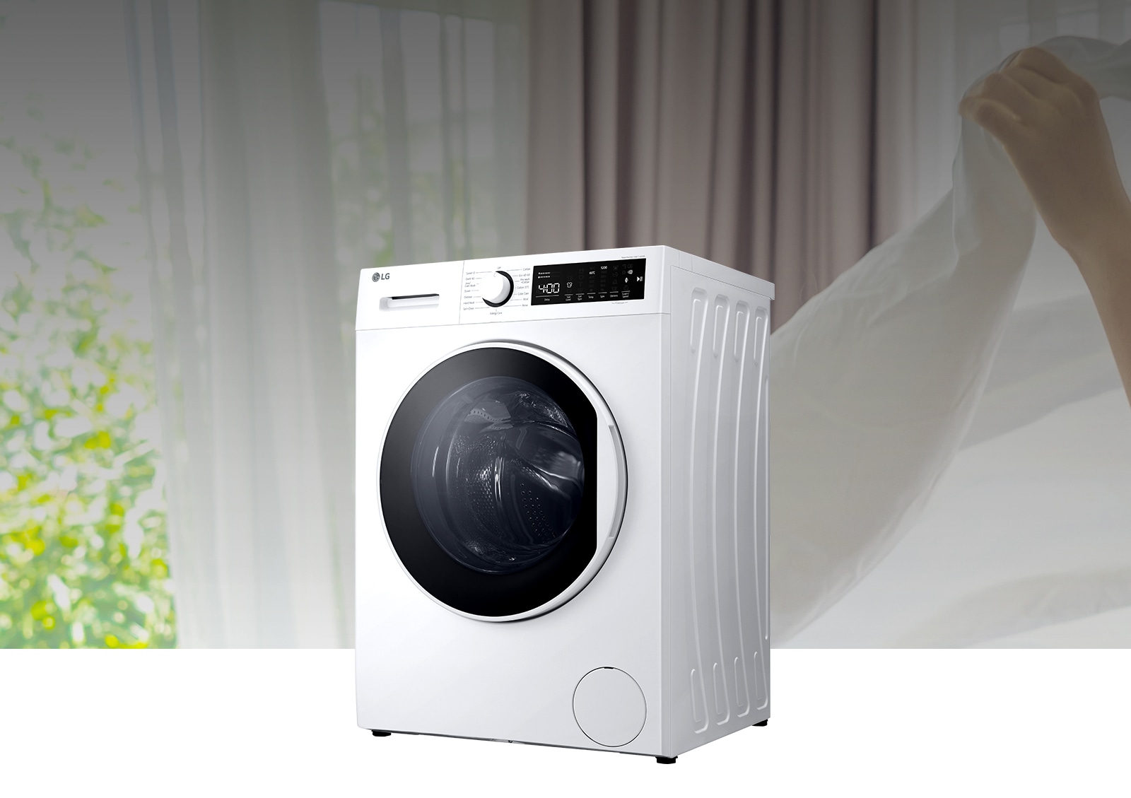 There is a washing machine in the background of spreading the white fabric.