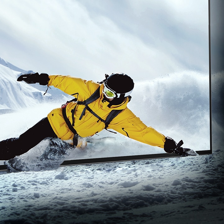 Un esquiador asomado a la pantalla del televisor LG OLED mientras la nieve cobra vida en la habitación.
