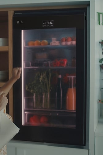 Kuva naisesta, joka koputtaa jääkaapin yläosaa.