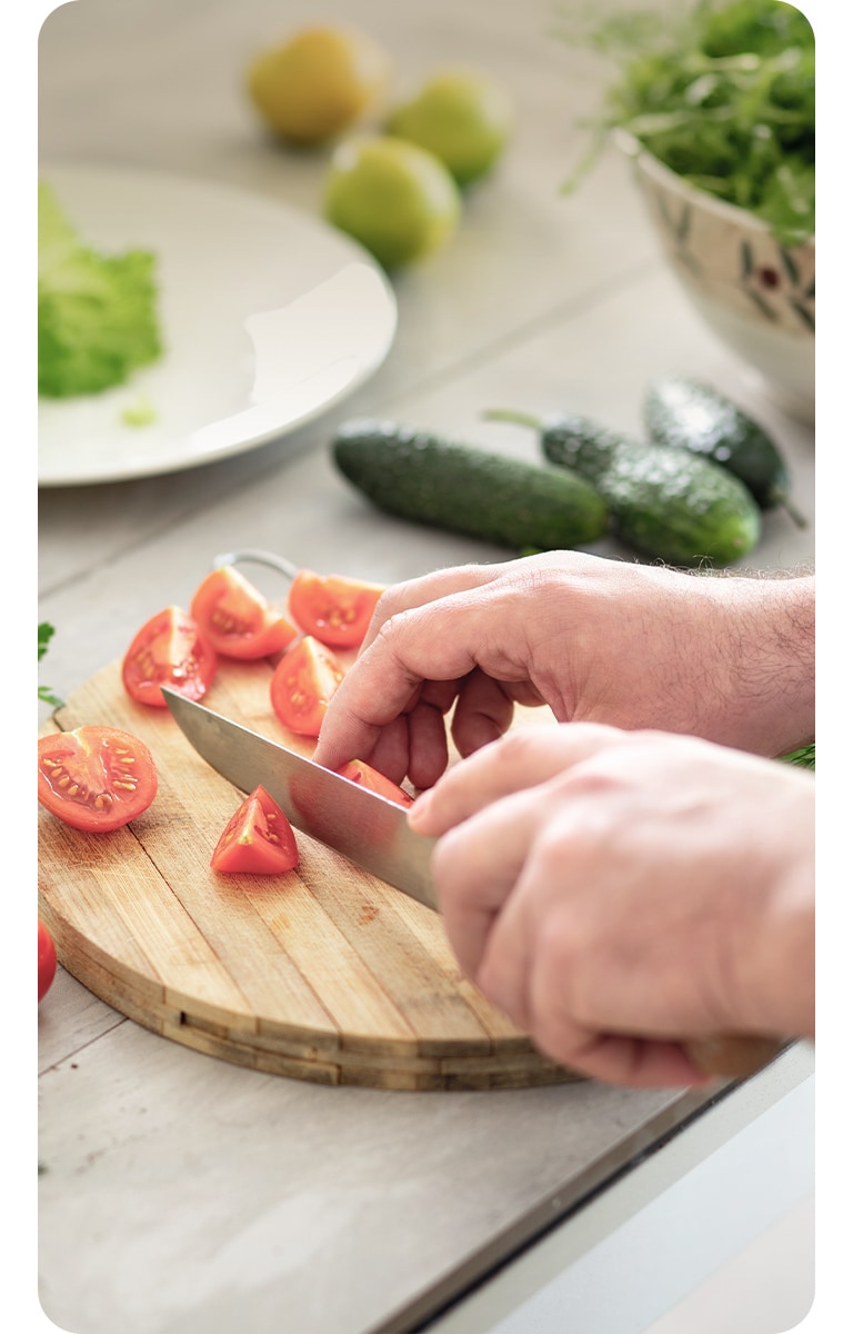 Kuva tomaattien leikkaamisesta leikkuuluadalla.