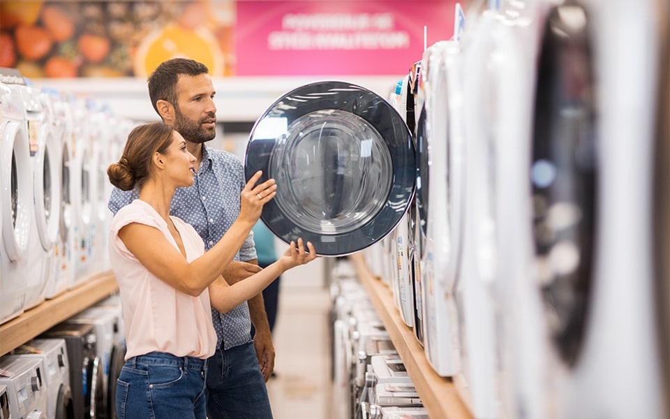 homme et femme regardant une machine à laver