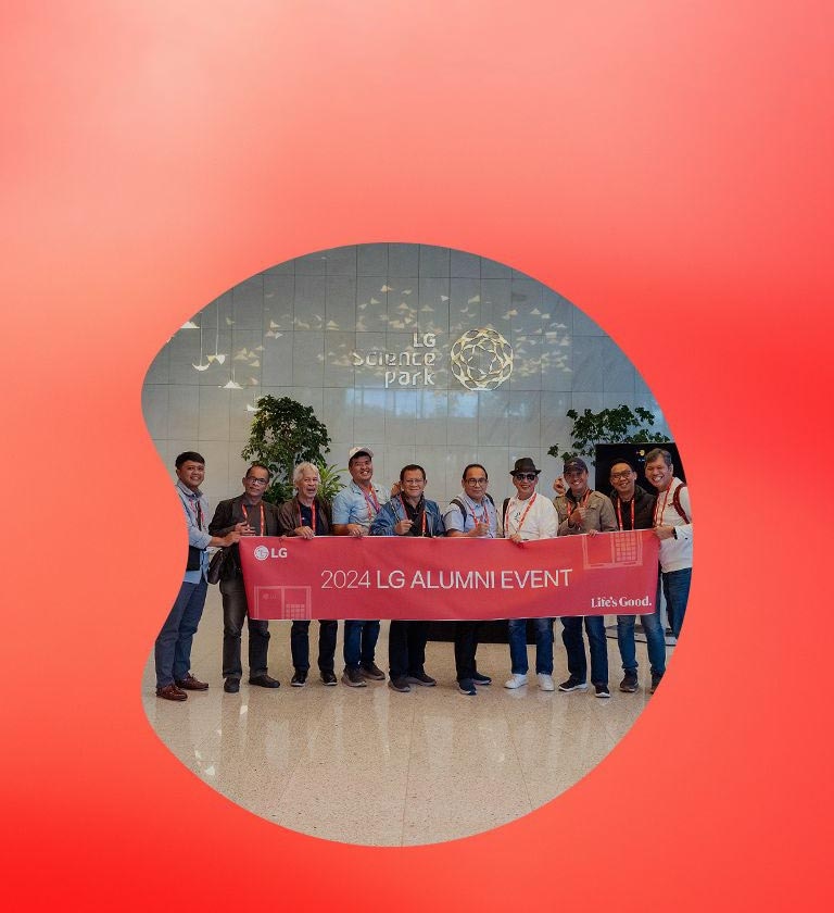 Group of people holding a banner that reads '2024 LG Alumni Event' in front of the LG Science Park.