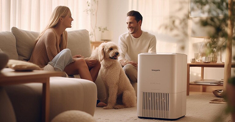 A woman and a man happily chit-chat in the living room with a dog between them. A close-up of the aircon can also be seen.