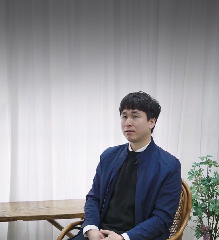 A man wearing blue jacket sitting on a chair 