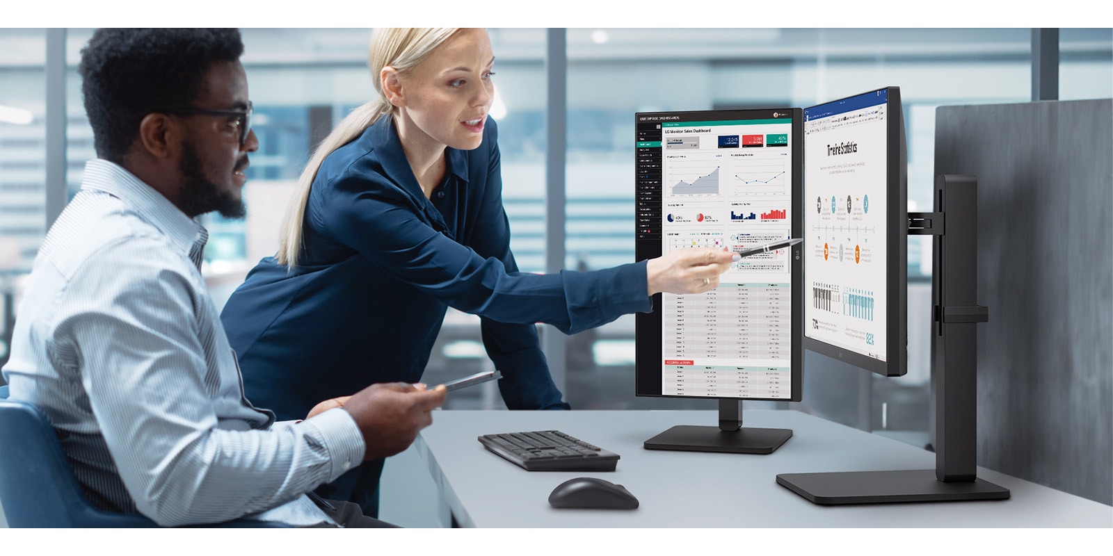 Two male and female employees discuss while looking at the monitor in the office. 