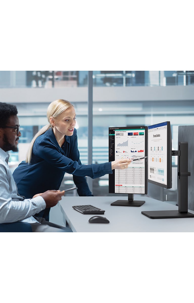 Two male and female employees discuss while looking at the monitor in the office.	