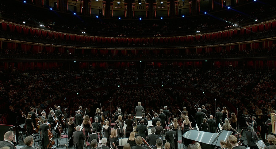 A full grand orchestra performs in a large theater