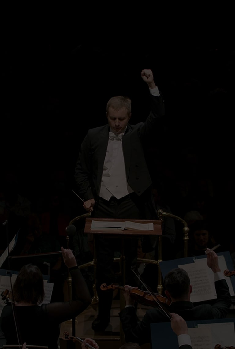 A conductor directs an orchestra. Overlayed text: 'The Musical Offering to the Whole World. #music #partnership'