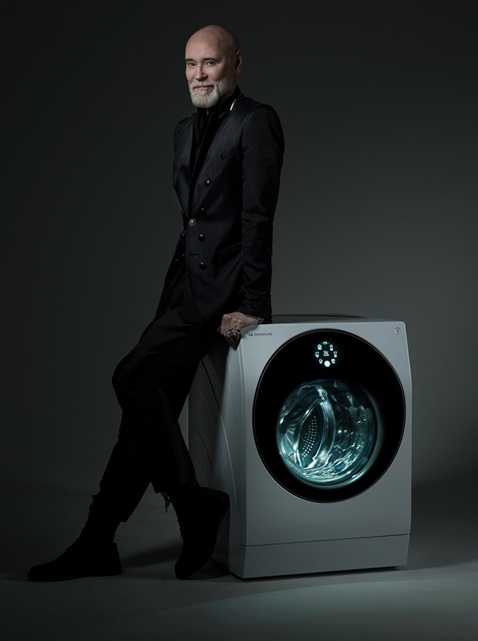 Fashion designer Lars Wallin leaning on a LG SIGNATURE Washing Machine, his signature written on the imagge