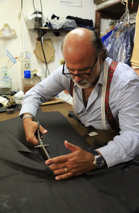A man cuts fabric with scissors.