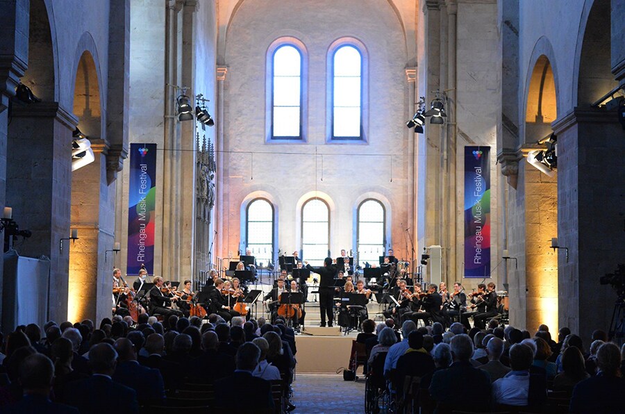 A small orchestra playing in front of a full audience inside the Eberbach Monastery during the Rheingau Musik Festival.