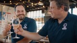 Thumbnail showing two men toasting with glasses of white wine. (play the video)