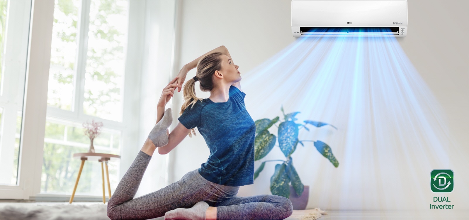 A woman stretching on the floor. In the background is the air conditioner blowing out "blue" air, blowing it over the woman and into the space. The Dual Inverter logo is in the lower right corner.
