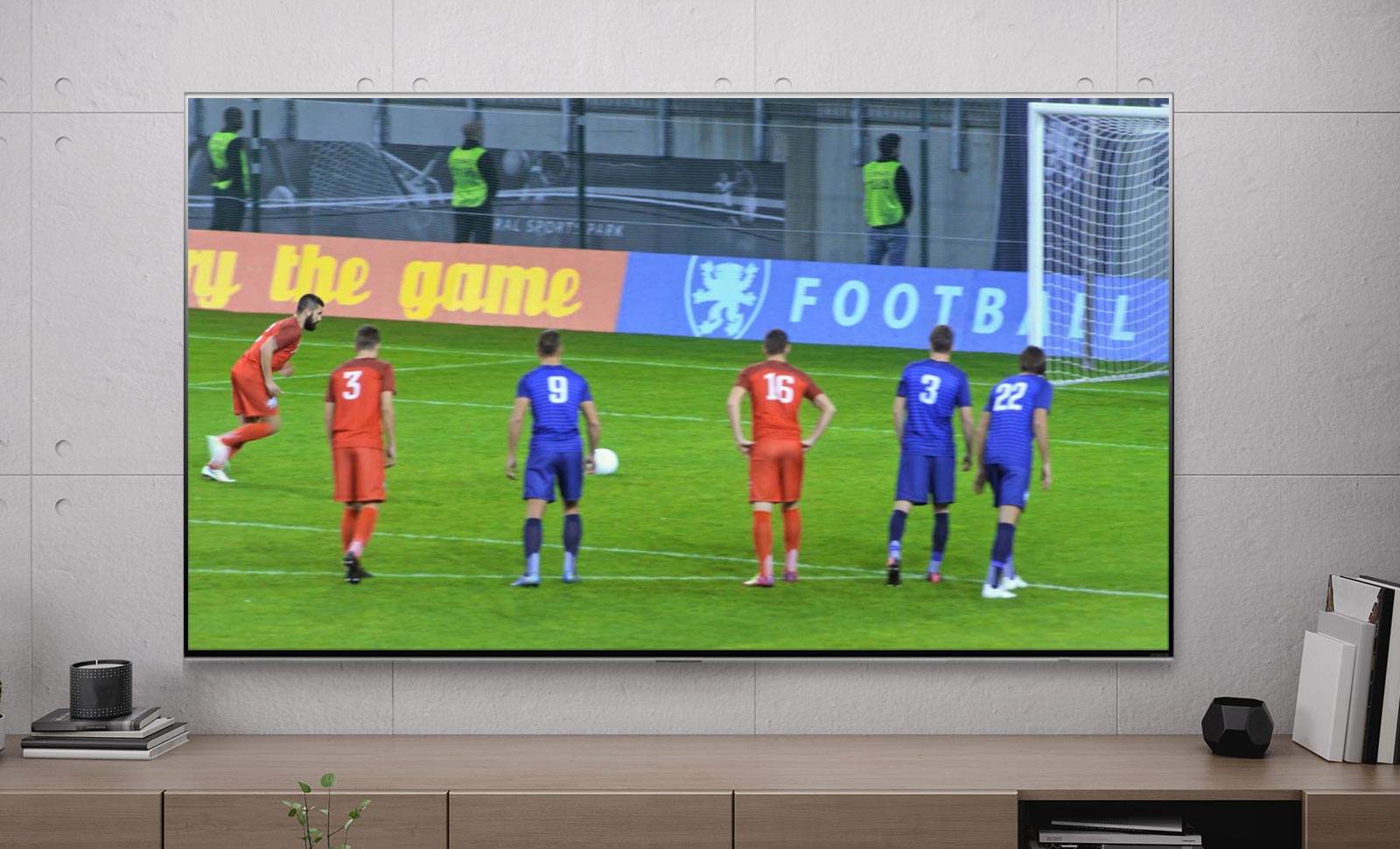 TV zaslon prikazuje nogometaša, ki je zadel enajstmetrovko (predvajaj video).