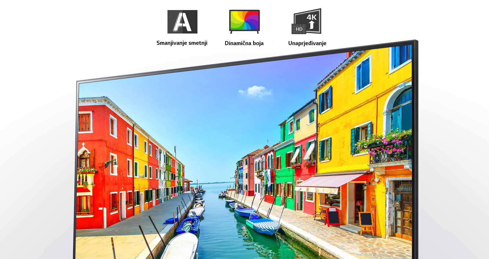 Na televizijskem zaslonu je prikazano pristaniško mesto, kjer so stavbe pobarvane v več barv in majhni čolni, zasidrani v dolgem in ozkem pristanišču. 