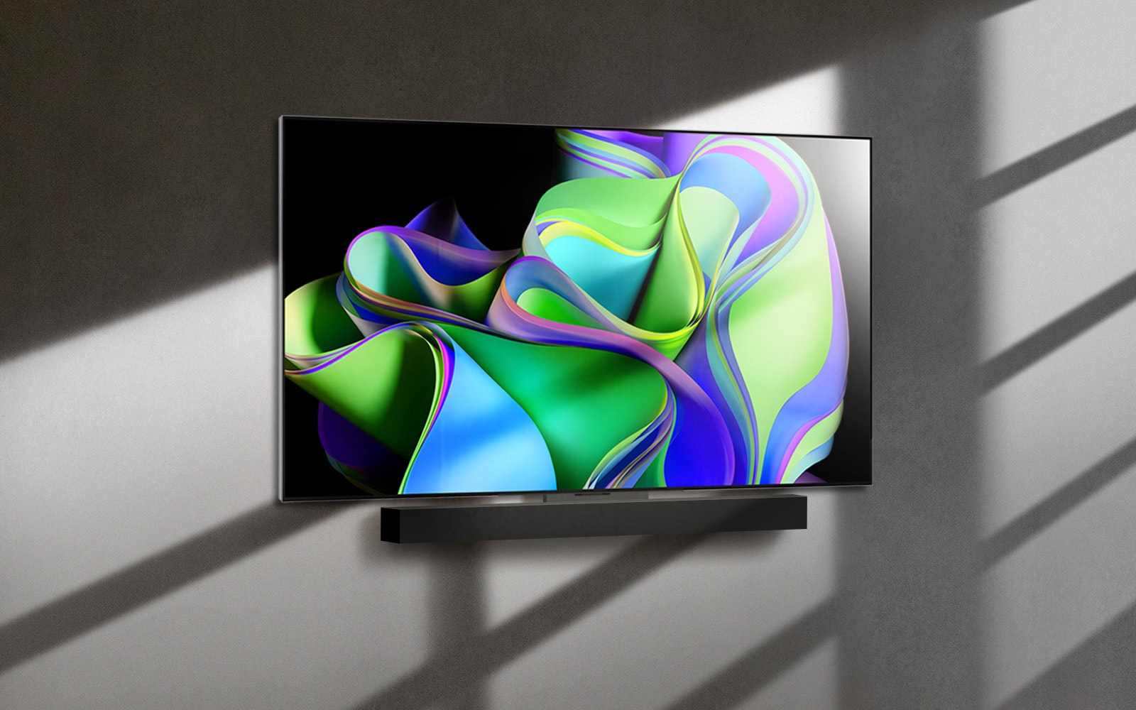 Video se začne z besedami LG OLED evo na črnem ozadju.  Besede so povečane in napolnjene z barvo.  Nato se prizor preklopi na LG OLED C3, ki prikazuje barvito abstraktno umetniško delo z zvočnikom Soundbar na belem ozadju.  Belo ozadje postane stena v prostoru, na katero je pritrjen televizor.