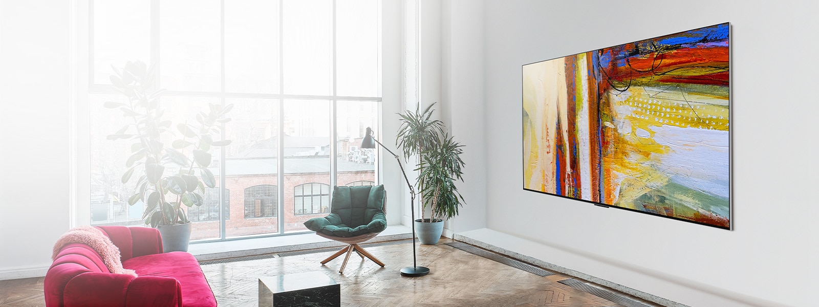 Slika televizorja LG OLED G3, ki prikazuje barvita abstraktna umetniška dela v svetli in živahni sobi.