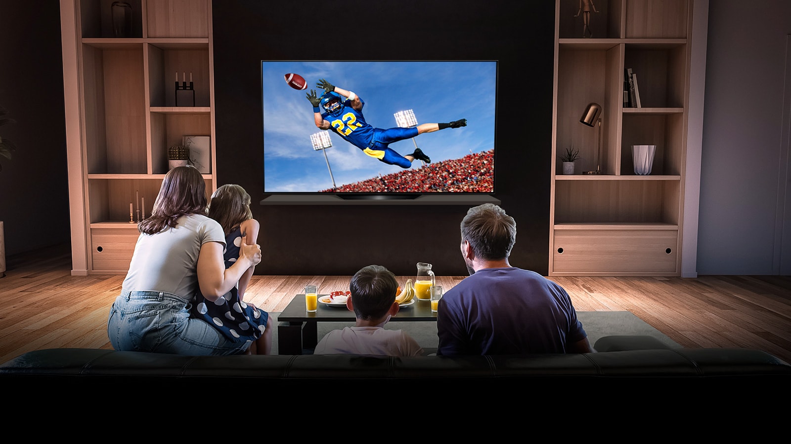 Az emberek egy amerikai futball játékot néznek a tévében a nappaliban